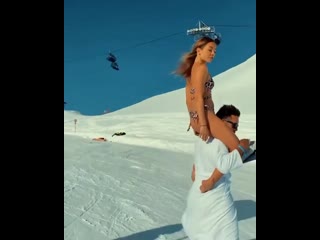 the girl swept on the neck of a snowboarder in a bikini. filmed at krasnaya polyana in sochi.